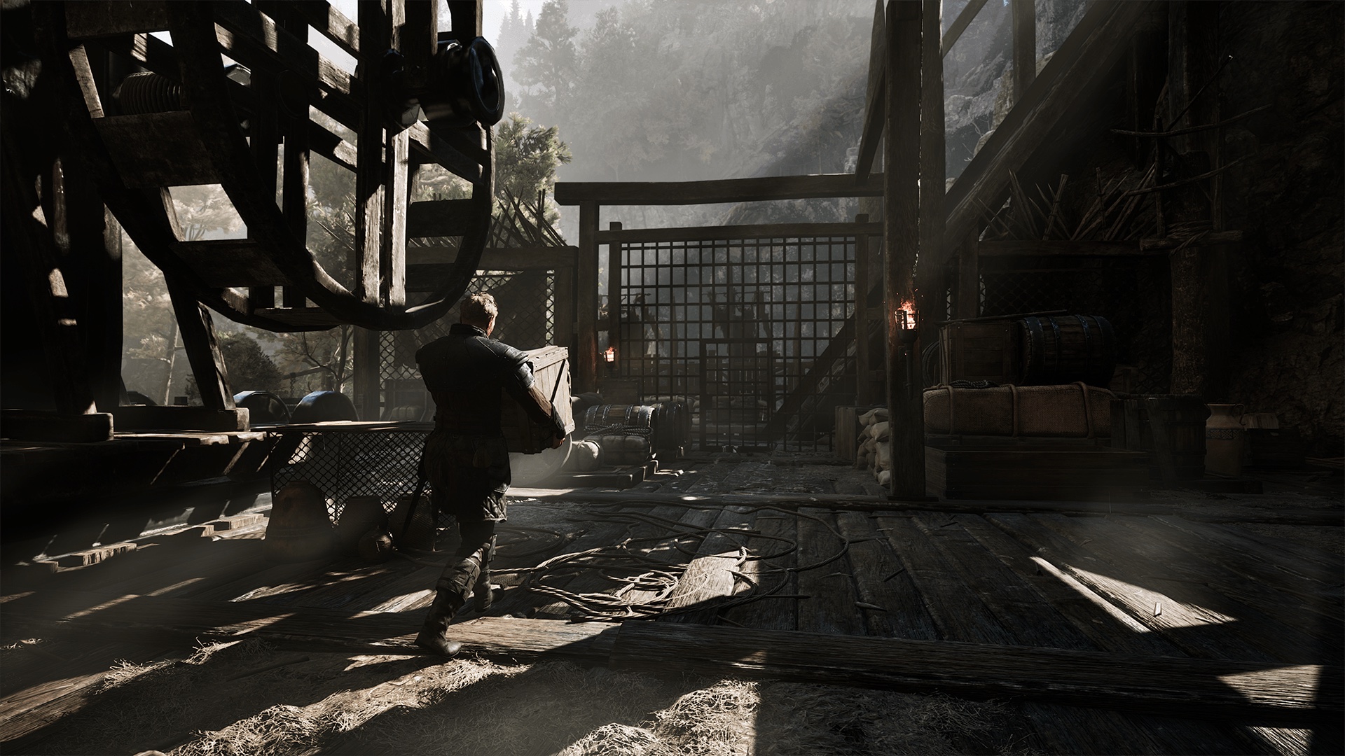 Gothic 1 Remake NPC guide — a colony worker hauls an ore crate through a timbered mine structure as other characters work nearby